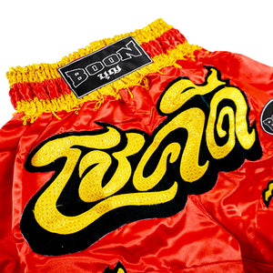 Red and yellow Boon traditional Muay Thai shorts with Thai lettering, Muay Thailand gear