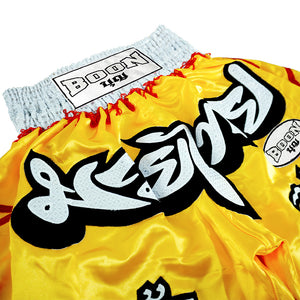 Boon yellow Muay Thai shorts with Thai lettering, red accents, and Boon USA label.