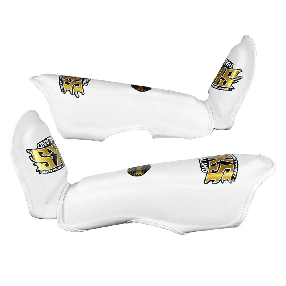 White leather Muay Thai shin pads with gold SKS Empire Thailand logo on white background