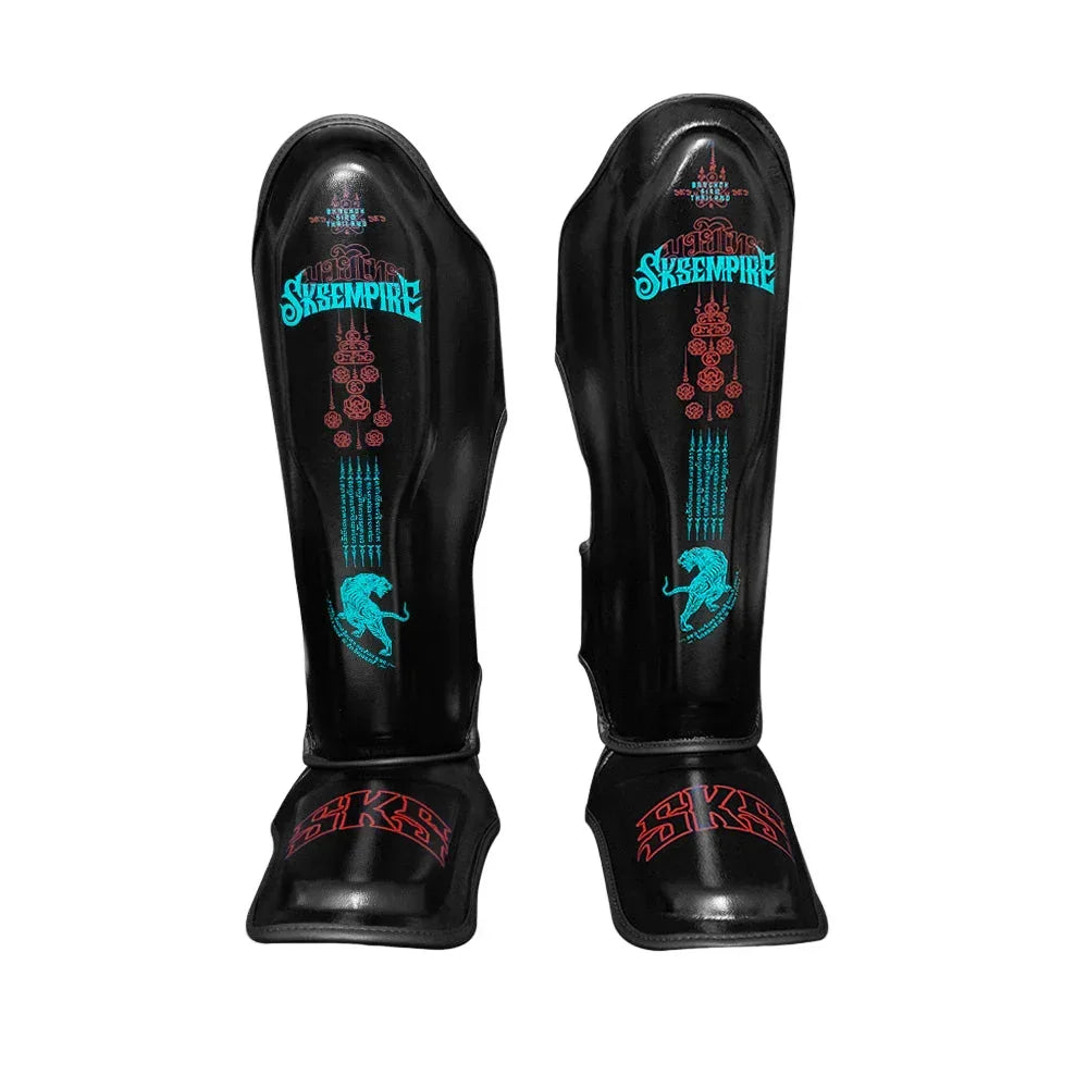 Black SKS Empire Muay Thai microfiber shin pads with blue and red tiger bomb design