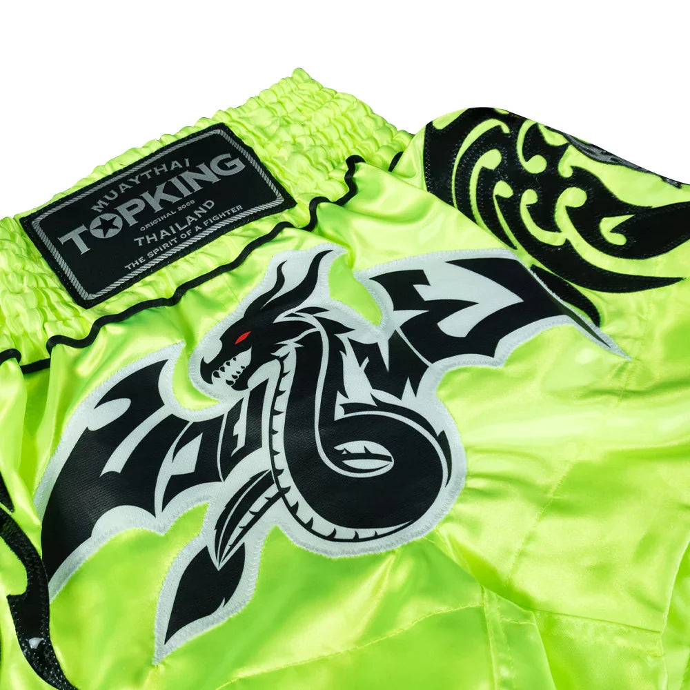 Top King Muay Thai shorts in neon green with black dragon embroidery and Thailand logo patch.