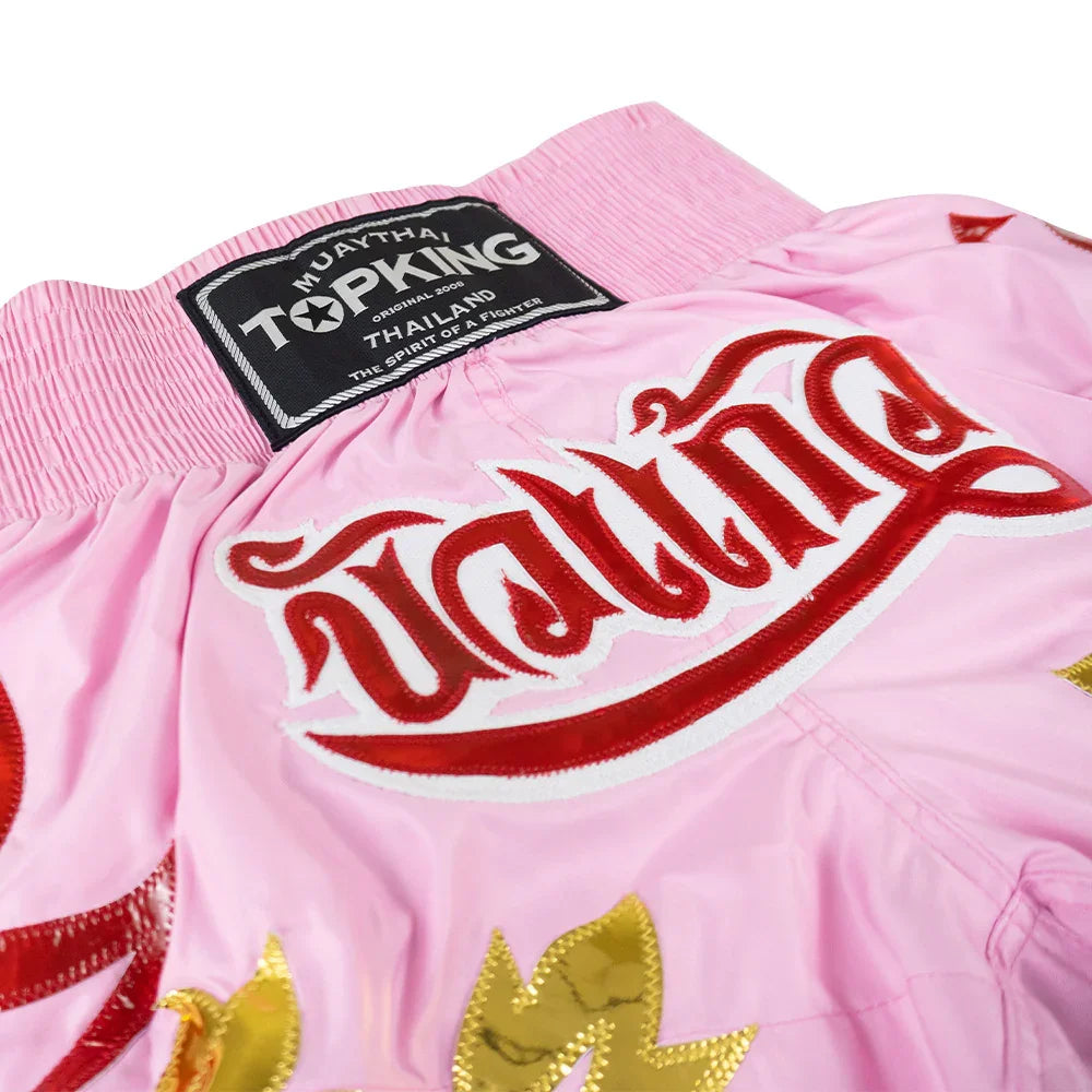 Top King Muay Thai pink shorts with red Thai script and gold accents