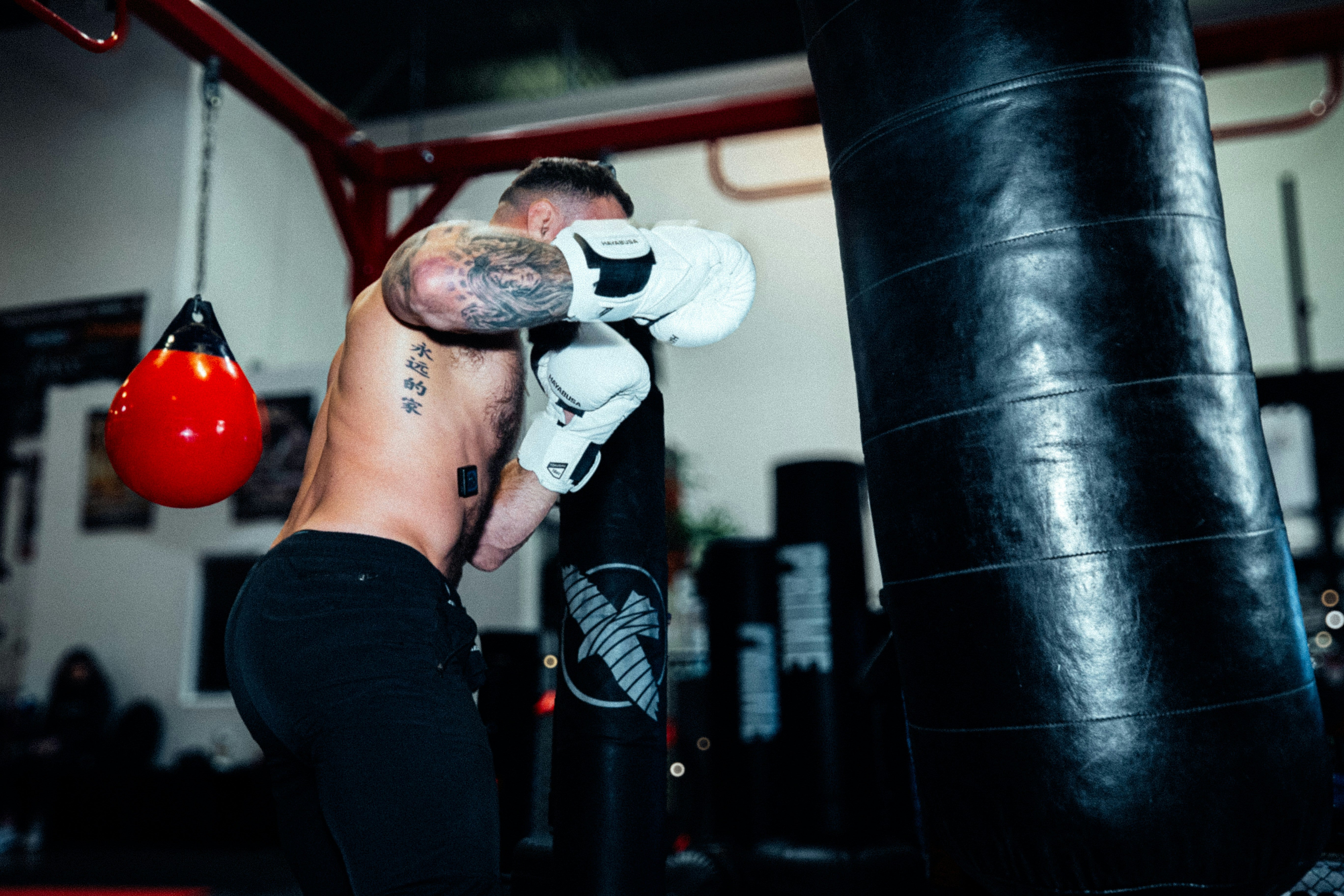 A man with white gloves hitting a heavy bag
