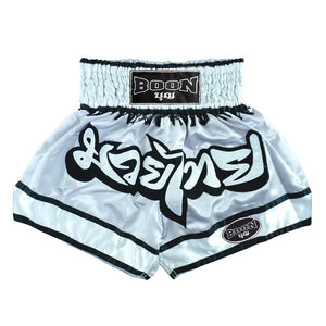 Close-up of Boon grey Muay Thai shorts with black trim and Thai script, premium fightwear.